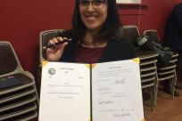 Legislative Aide Melissa Kookesh holding SB 28 and the pen the Governor used to sign it with.